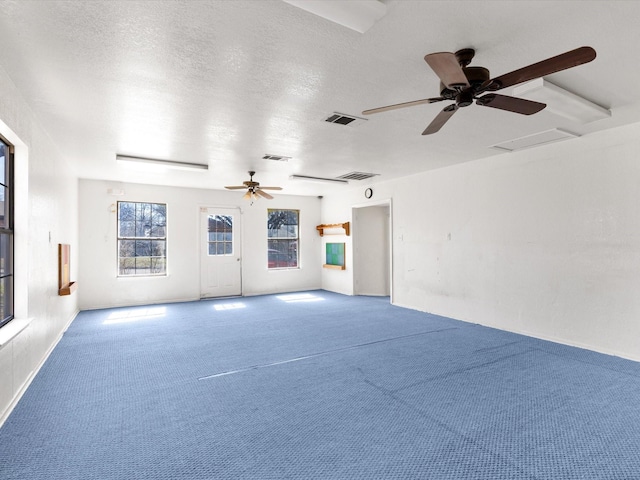 carpeted empty room featuring ceiling fan and a textured ceiling