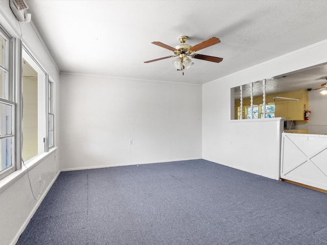 empty room featuring ornamental molding, carpet flooring, and ceiling fan