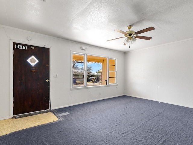 entrance foyer with carpet floors, ornamental molding, a textured ceiling, and ceiling fan