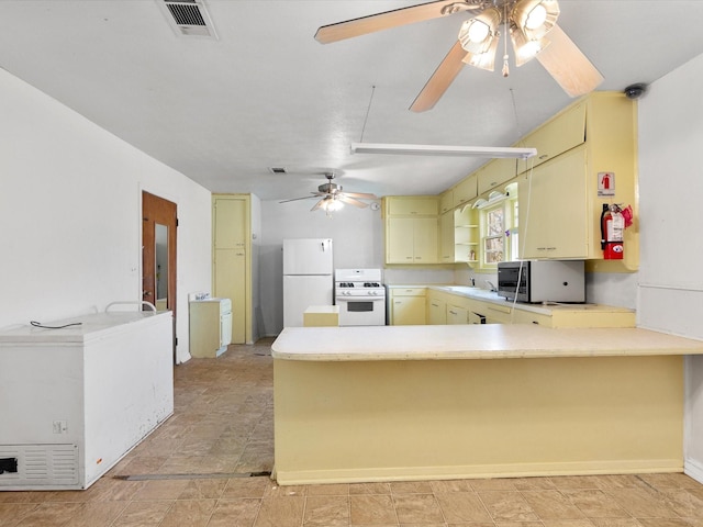 kitchen with sink, kitchen peninsula, white appliances, and ceiling fan