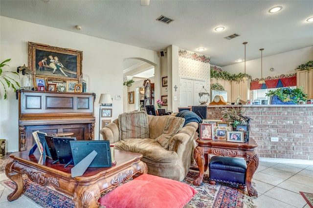 living room featuring arched walkways, light tile patterned floors, visible vents, and recessed lighting