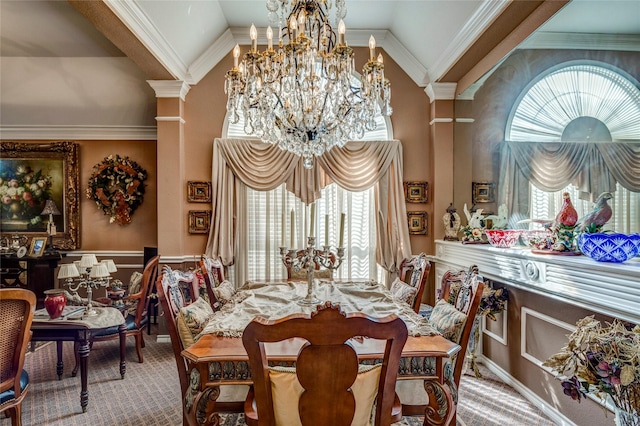 carpeted dining room featuring a wainscoted wall, a notable chandelier, ornamental molding, high vaulted ceiling, and ornate columns