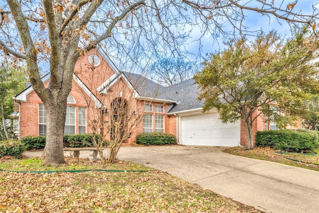 view of front of property with a garage, concrete driveway, brick siding, and roof with shingles