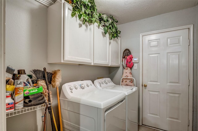 clothes washing area featuring washer and dryer, cabinet space, and a textured ceiling