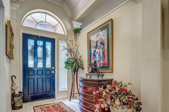 foyer entrance with ornamental molding and light tile patterned flooring