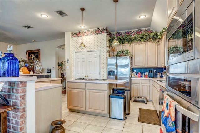 kitchen featuring a center island, decorative light fixtures, light countertops, visible vents, and appliances with stainless steel finishes