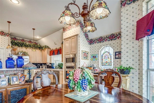 dining area with a healthy amount of sunlight, wallpapered walls, and vaulted ceiling