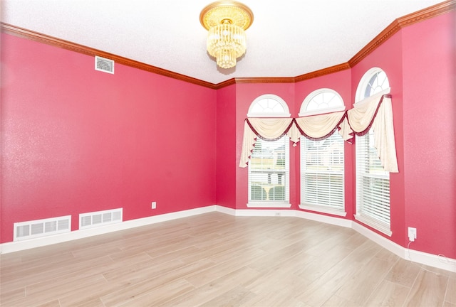 unfurnished room featuring hardwood / wood-style floors, a chandelier, and crown molding