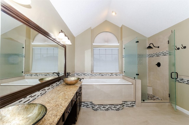 bathroom with vanity, shower with separate bathtub, vaulted ceiling, and tile patterned floors