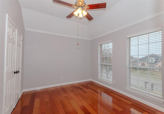 unfurnished room featuring hardwood / wood-style flooring, ceiling fan, vaulted ceiling, and ornamental molding