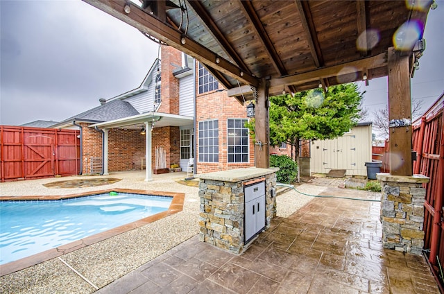 view of pool with a shed and a patio area