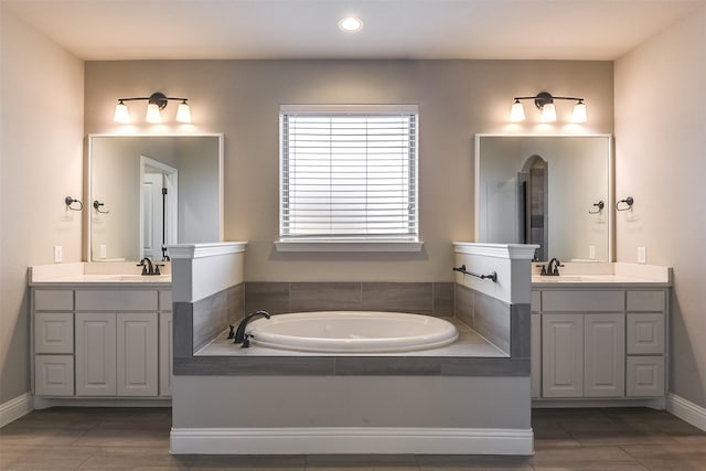 bathroom featuring vanity and a relaxing tiled tub