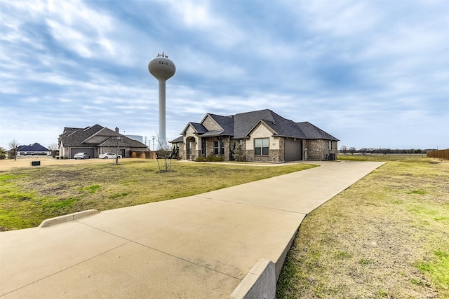 french provincial home with a front lawn and a garage