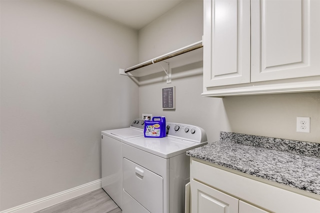 washroom featuring light hardwood / wood-style floors, cabinets, and washing machine and clothes dryer