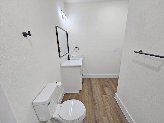 bathroom featuring hardwood / wood-style flooring, vanity, and toilet