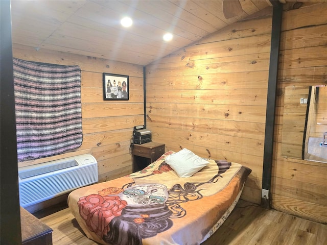 bedroom featuring light wood-type flooring, vaulted ceiling, and wood walls