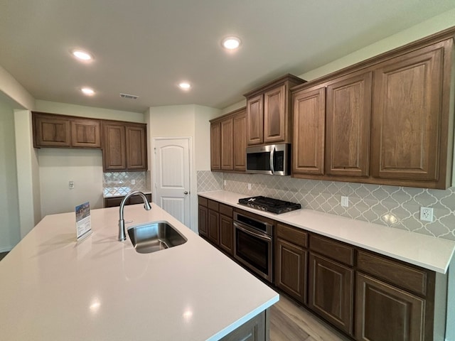 kitchen featuring appliances with stainless steel finishes, visible vents, light countertops, and a sink