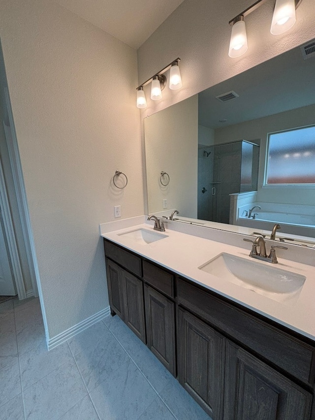 bathroom featuring double vanity, visible vents, a shower stall, and a sink