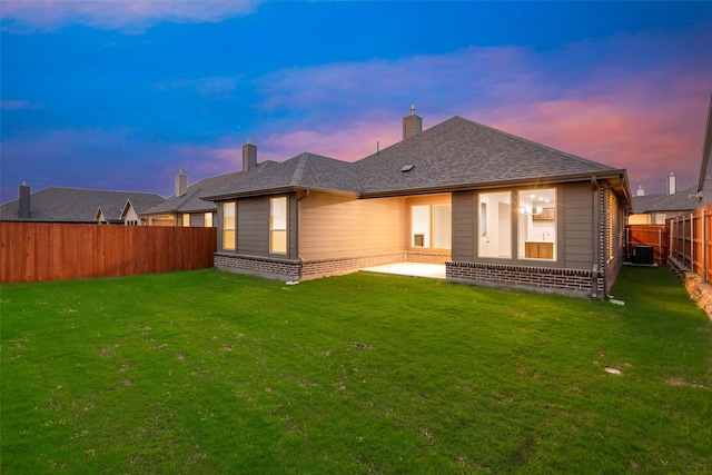 14317 Nebula Dr, Haslet, TX 76052 - back of property at dusk with a yard, a fenced backyard, and central AC