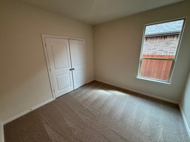 unfurnished bedroom featuring a closet, carpet flooring, and baseboards