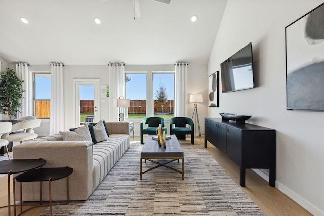living room with light hardwood / wood-style flooring and vaulted ceiling