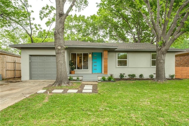 view of front of property featuring brick siding, fence, a garage, driveway, and a front lawn