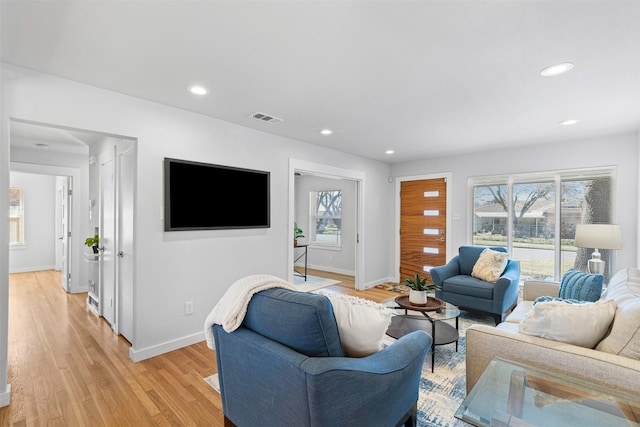 living area with recessed lighting, baseboards, visible vents, and light wood finished floors