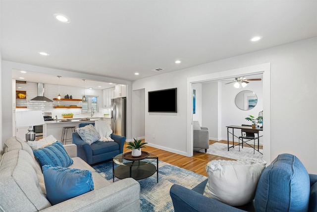 living room with light wood finished floors, recessed lighting, visible vents, ceiling fan, and baseboards