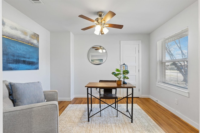 office area featuring baseboards, ceiling fan, and light wood finished floors