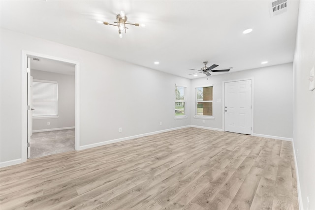 empty room featuring light wood-style floors, recessed lighting, visible vents, and baseboards