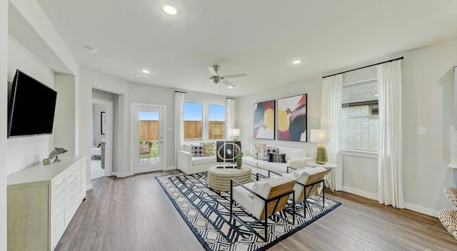 living room with ceiling fan and light hardwood / wood-style floors