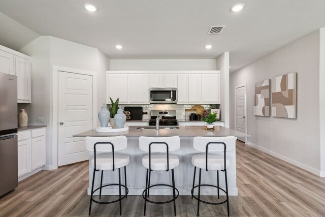 kitchen with white cabinets, an island with sink, and appliances with stainless steel finishes