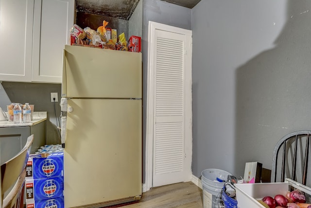 interior space with light wood-type flooring, white cabinets, and white refrigerator