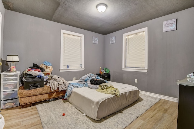 bedroom with a textured ceiling and hardwood / wood-style floors