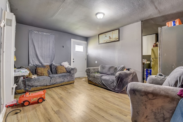 living room with light wood-type flooring and a textured ceiling