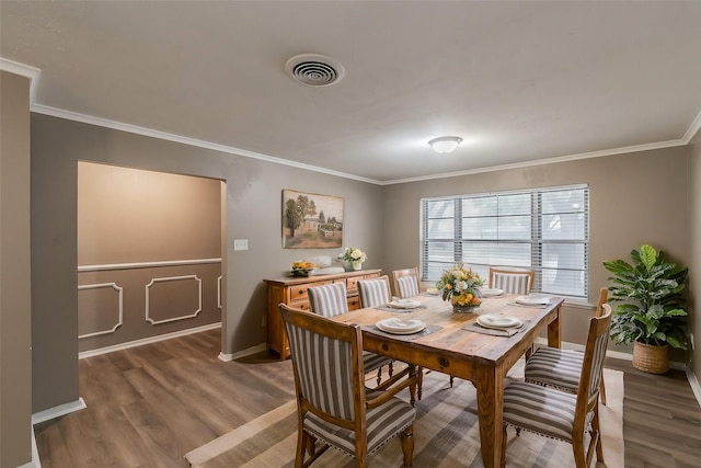 dining room featuring hardwood / wood-style floors and crown molding