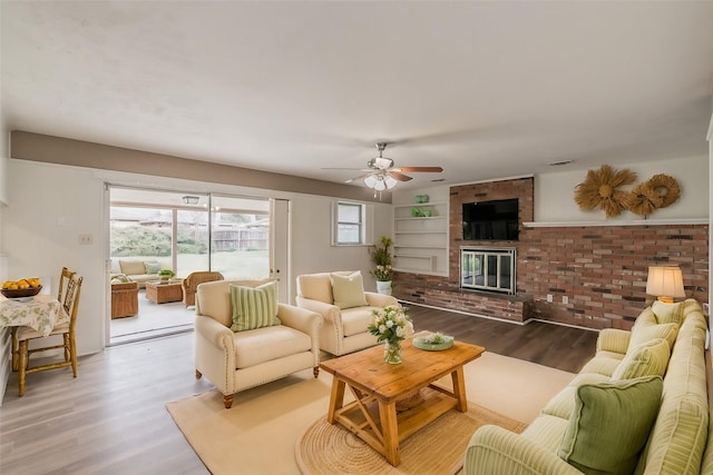 living room featuring a fireplace, ceiling fan, and wood-type flooring