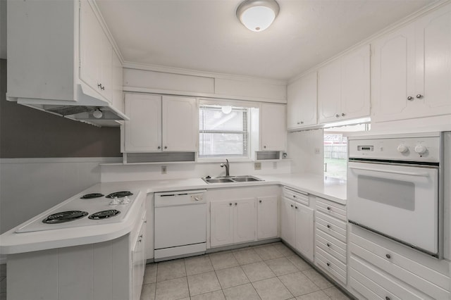 kitchen featuring white cabinetry, sink, white appliances, light tile patterned floors, and crown molding