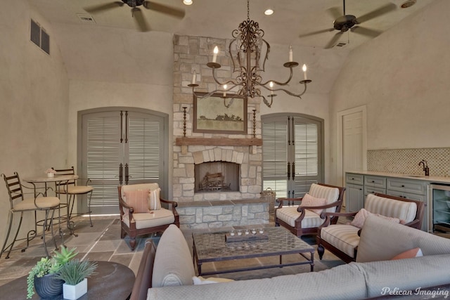 living room with french doors, high vaulted ceiling, beverage cooler, a fireplace, and sink