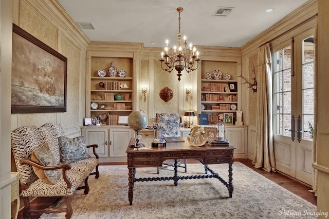 office space with wood-type flooring, crown molding, plenty of natural light, and built in shelves