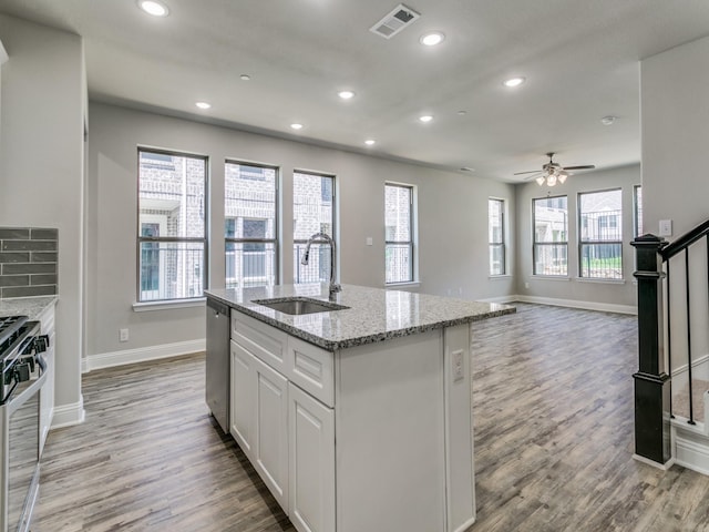 kitchen featuring a center island with sink, visible vents, white cabinets, appliances with stainless steel finishes, and a sink