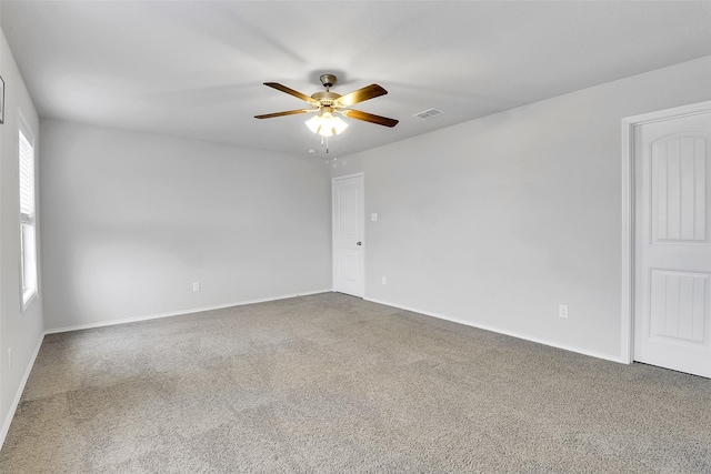 empty room with baseboards, carpet, visible vents, and a ceiling fan