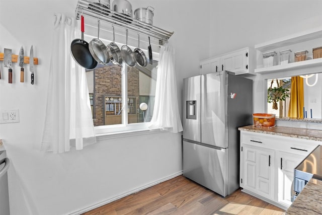 821 Dublin Dr Unit 143, Richardson, TX 75080 - kitchen with light wood finished floors, white cabinetry, stainless steel fridge, and light stone countertops