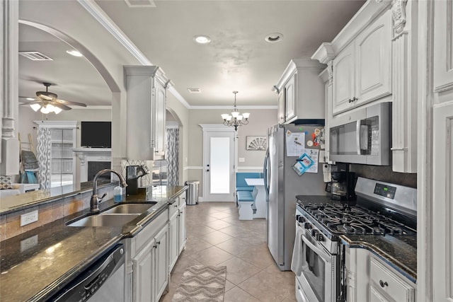 kitchen with white cabinets, dark stone countertops, stainless steel appliances, and sink