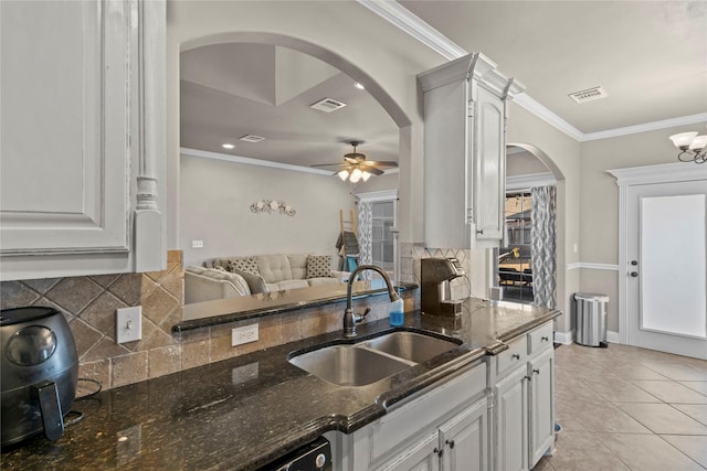 kitchen featuring sink, dark stone countertops, and white cabinets