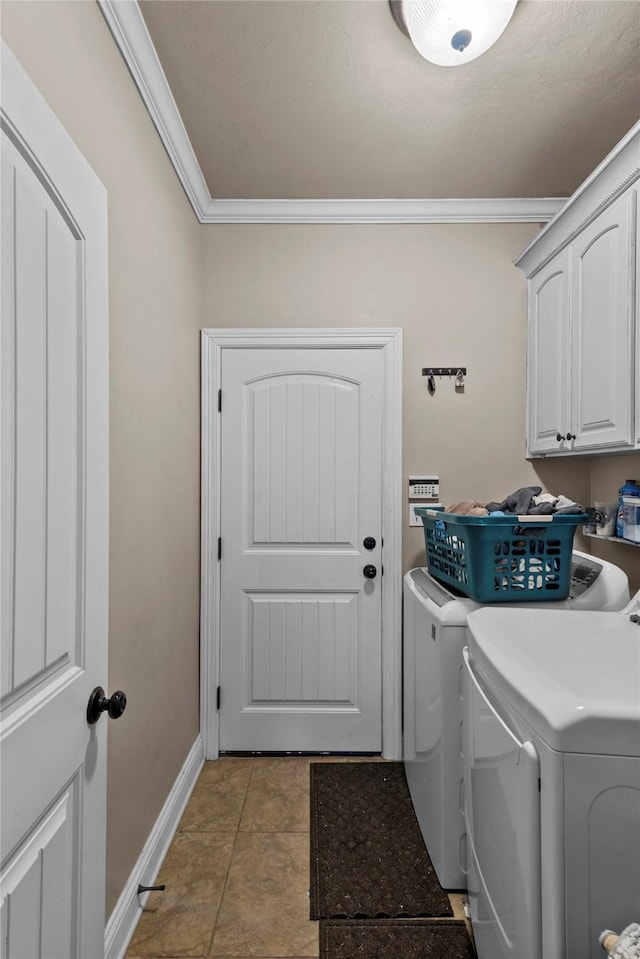 laundry area featuring washing machine and dryer, cabinets, and ornamental molding