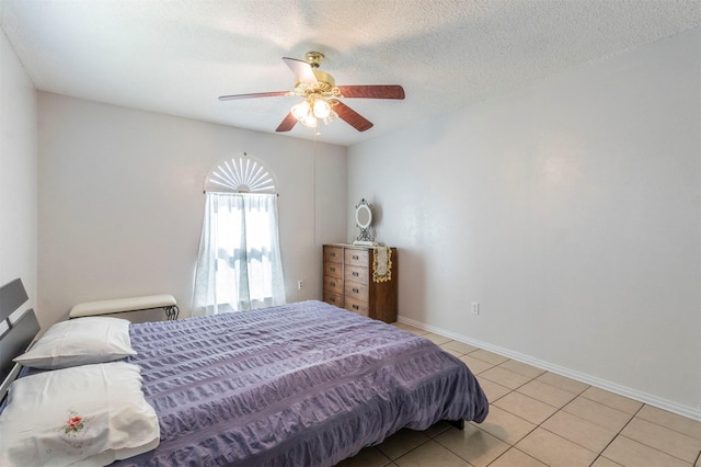 tiled bedroom featuring ceiling fan and a textured ceiling