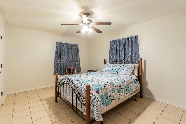 bedroom featuring ceiling fan, light tile patterned floors, and a textured ceiling