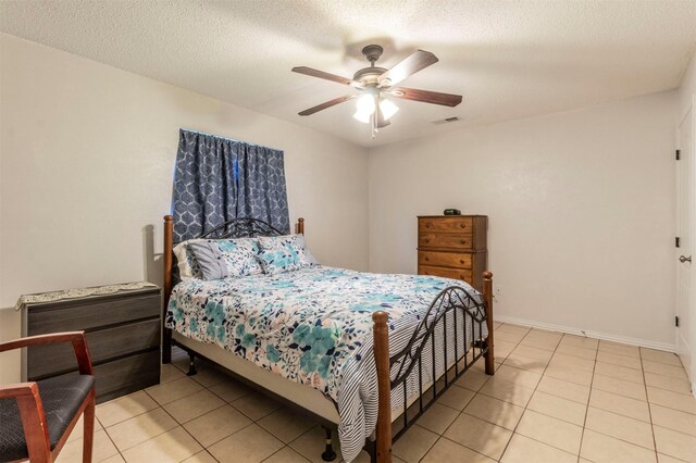 tiled bedroom featuring ceiling fan and a textured ceiling