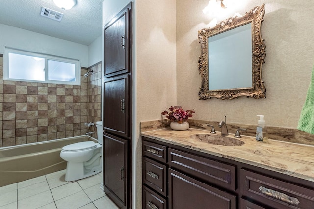 full bathroom with tiled shower / bath, toilet, a textured ceiling, tile patterned floors, and vanity